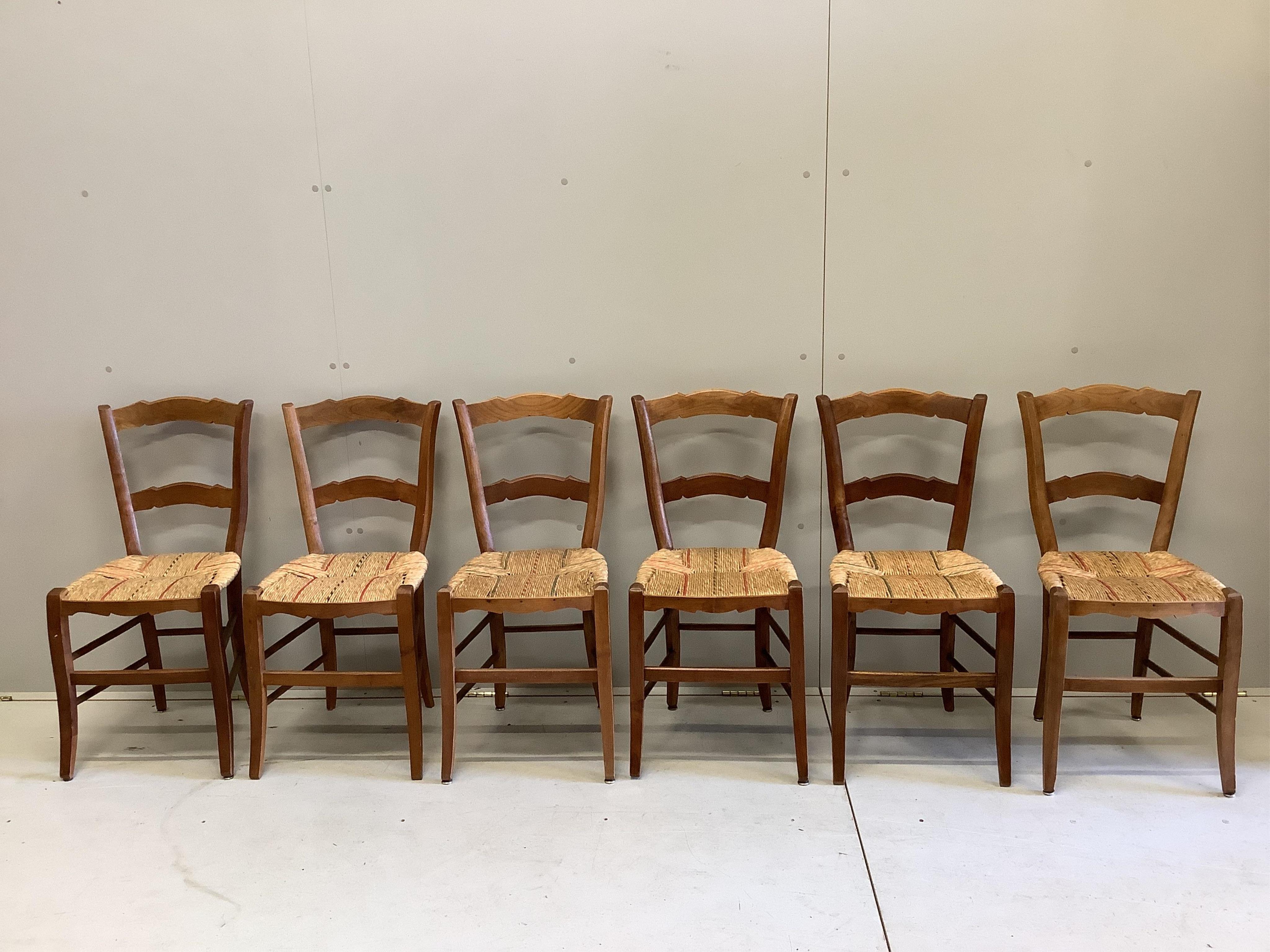 A set of six 19th century French fruitwood kitchen chairs, with rush seats, height 82cm. Condition - fair